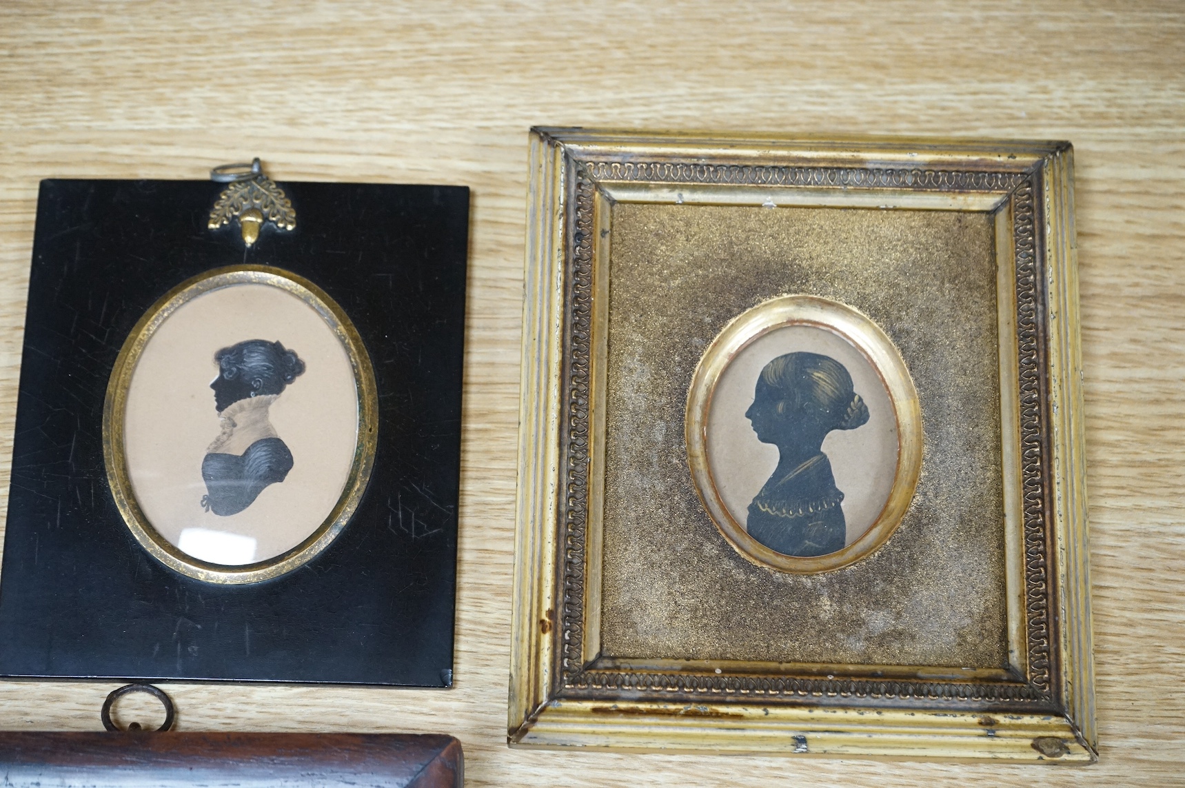 Four early to mid 19th century English School, hand painted silhouette portraits to include a Lady in Regency dress, largest 10 x 7cm. Condition - fair